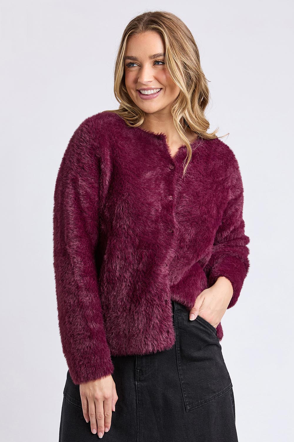 A model wearing the Kenny Button Cardi in colour Windwine (Red), from the front, cropped image