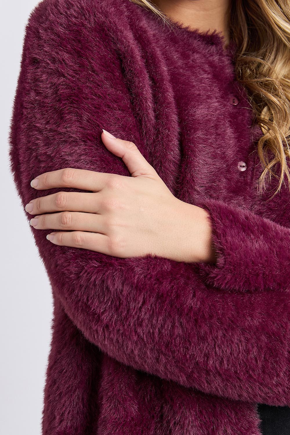 A model wearing the Kenny Button Cardi in colour Windwine (Red), from the front, cropped image