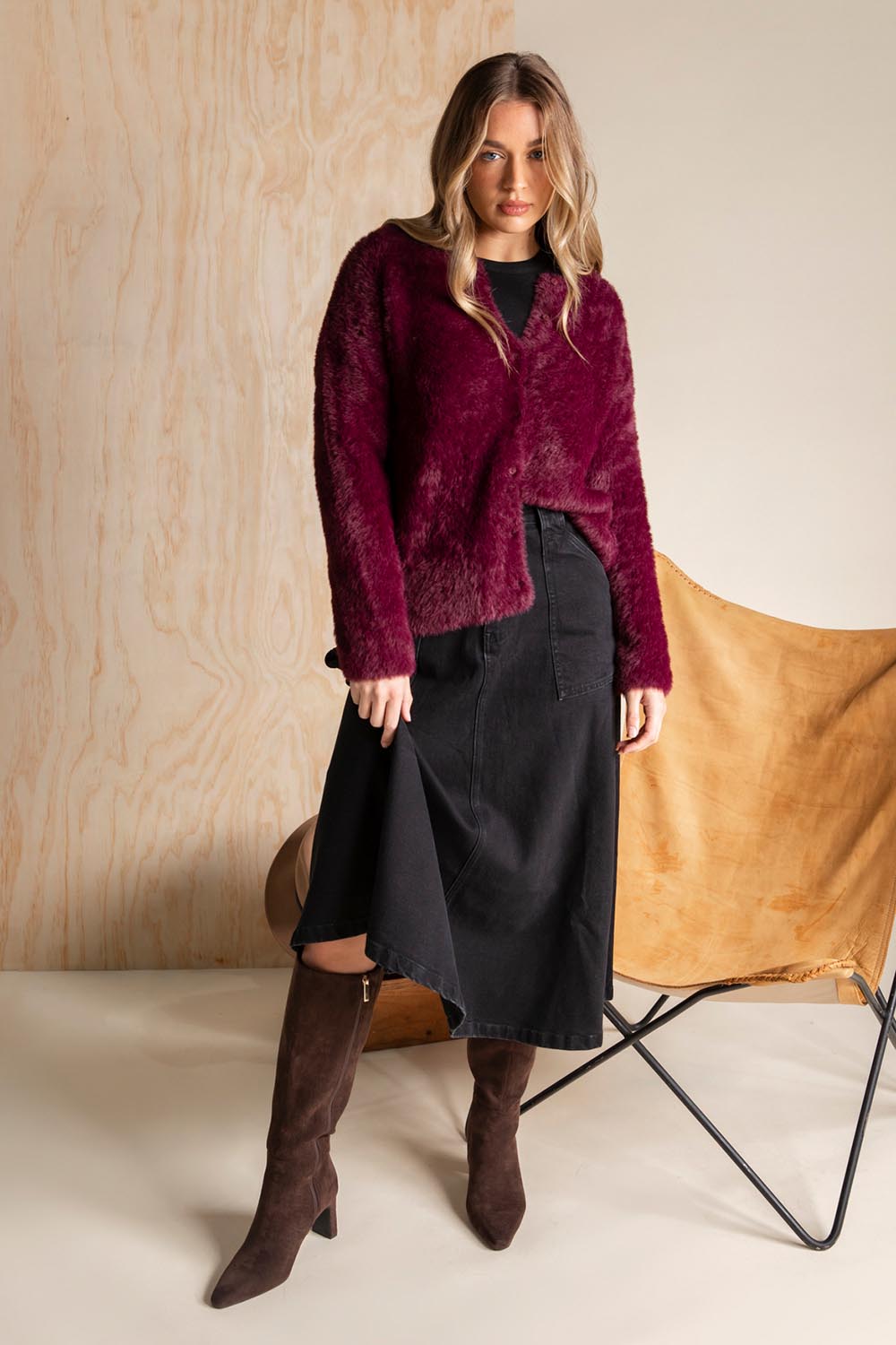 A model wearing the Kenny Button Cardi in colour Windwine (Red), from the front, showing the whole outfit