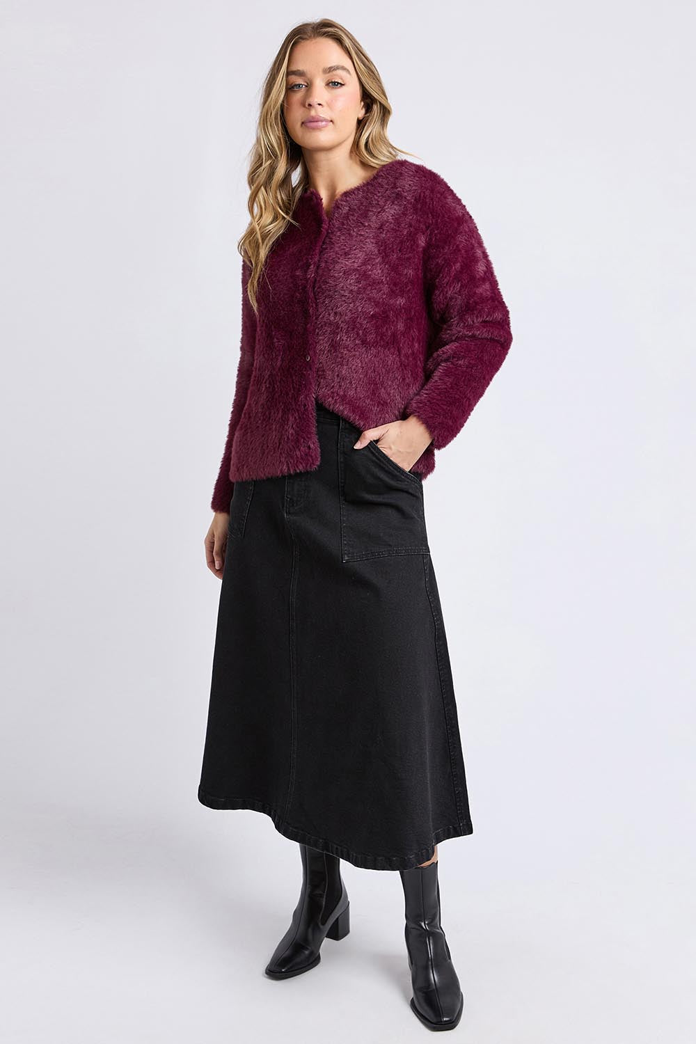 A model wearing the Kenny Button Cardi in colour Windwine (Red), from the front, showing the whole outfit