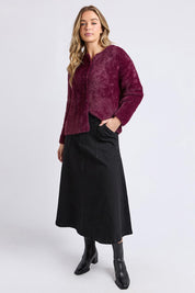 A model wearing the Kenny Button Cardi in colour Windwine (Red), from the front, showing the whole outfit