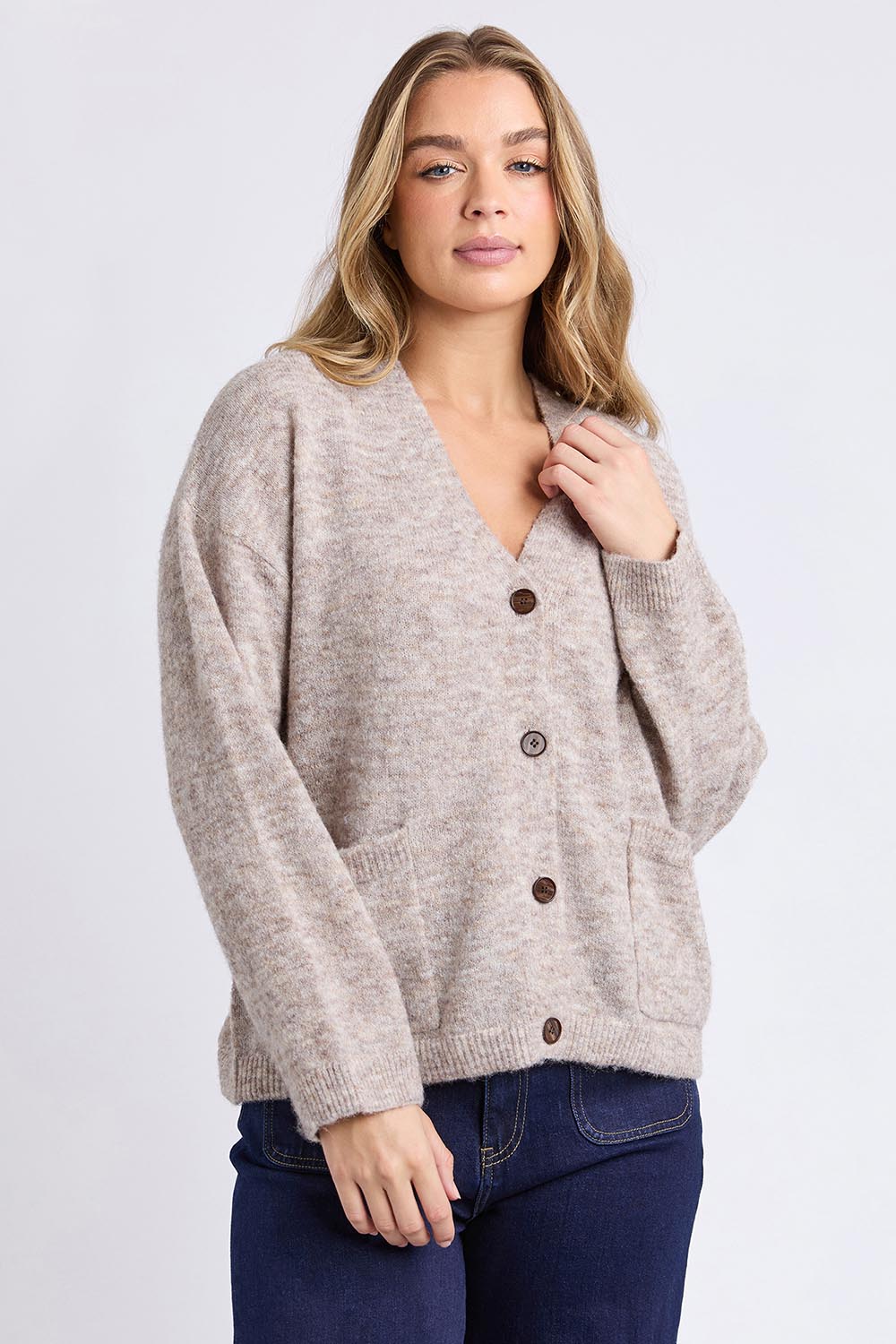 A model wearing the Emarie Cardi in colour Oatmeal, from the front, cropped image