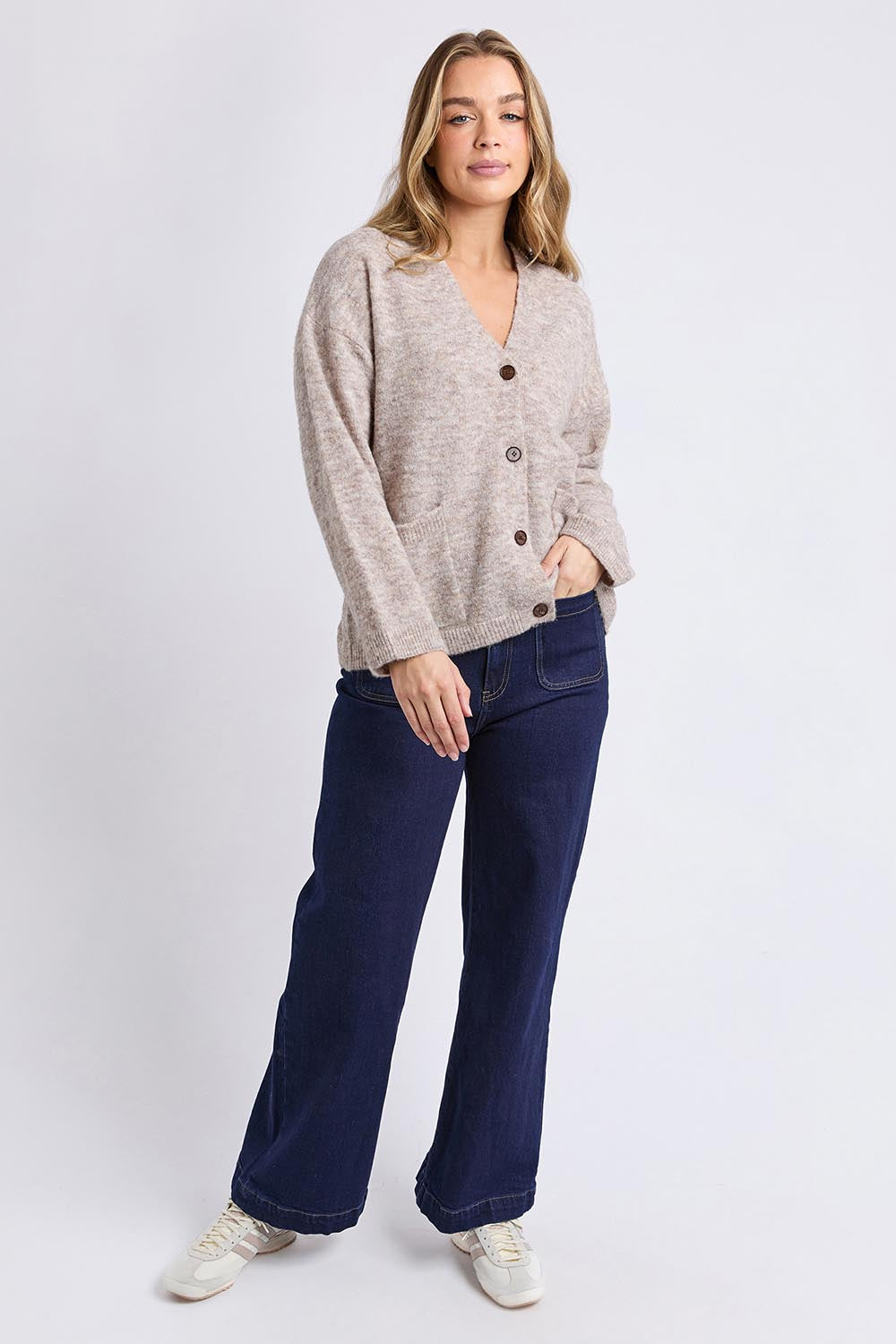 A model wearing the Emarie Cardi in colour Oatmeal, from the front, showing the whole outfit