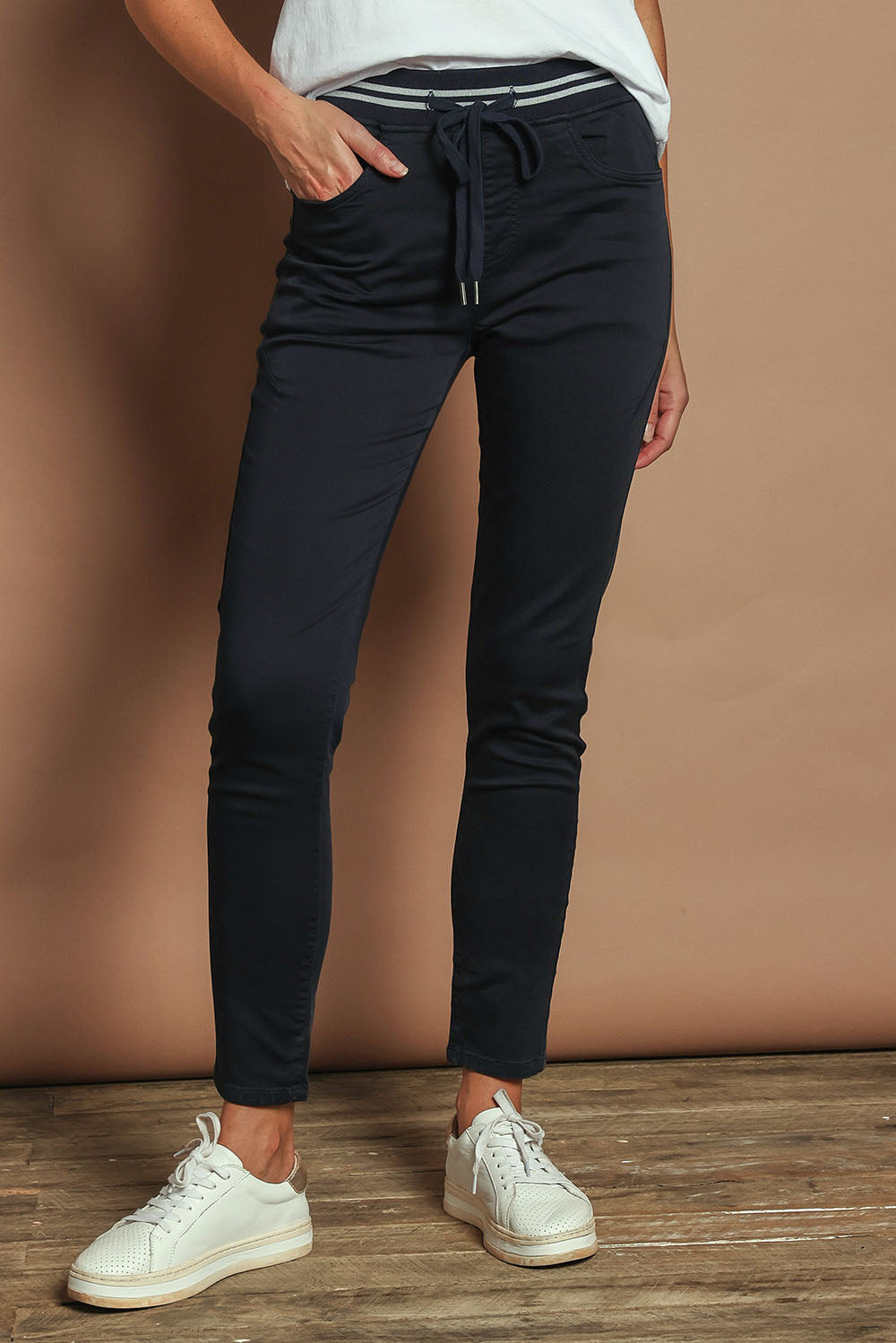 Model Madeline wearing size 10 of the Elements Sylvia Jogger in colour Navy (Blue), from the front, cropped image