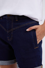 A model wearing the Elements Devi Denim Shorts in colour Darkblue (Blue), from the front, cropped image