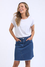 A model wearing the Elements Belle Skirt in colour Midblue (Blue), from the front, cropped image