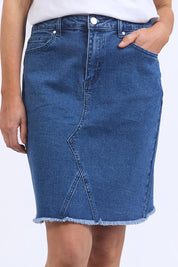 A model wearing the Elements Belle Skirt in colour Midblue (Blue), from the front, cropped image
