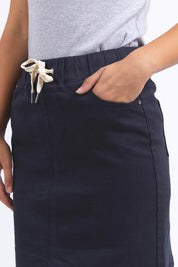 A model wearing the Elements Rio Skirt in colour Navy (Blue), from the front, cropped image