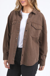 A model wearing the Daisy Denim Overshirt in colour Chocolate, from the front, cropped image
