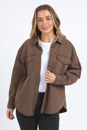 A model wearing the Daisy Denim Overshirt in colour Chocolate, from the front, cropped image