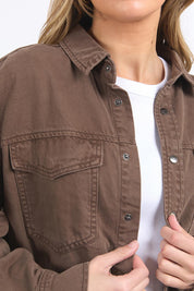 A model wearing the Daisy Denim Overshirt in colour Chocolate, from the front, cropped image
