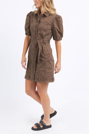 A model wearing the Talbert Dress in colour Chocolate, from the front, cropped image