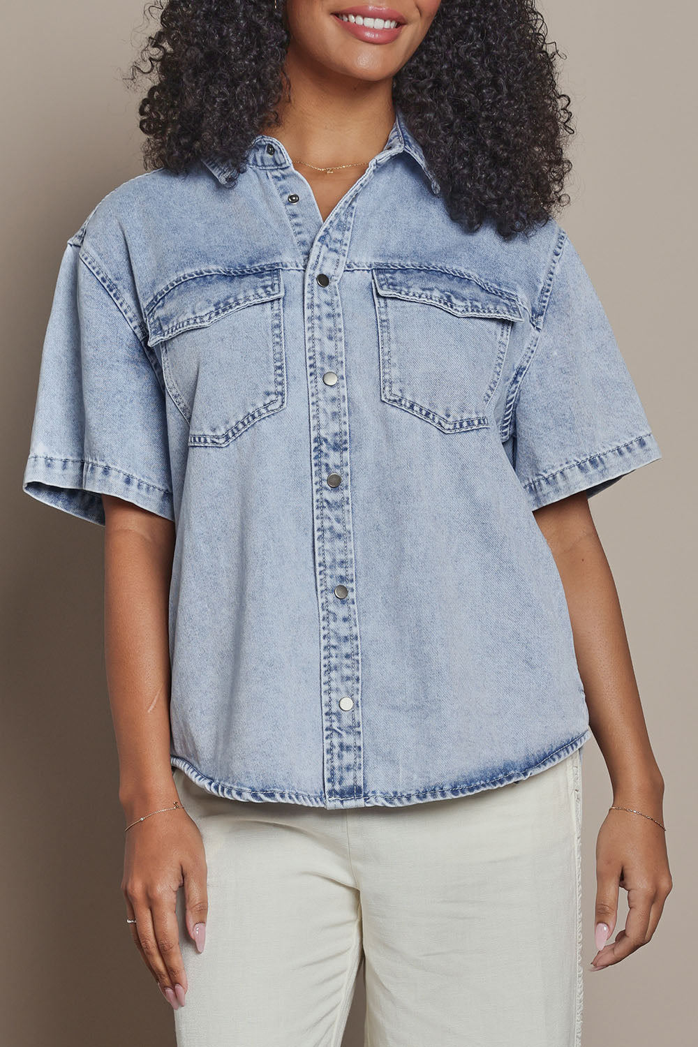 Model Ziara wearing size 10 of the Daisy Denim Ss Shirt in colour Lightblue (Blue), from the front, cropped image