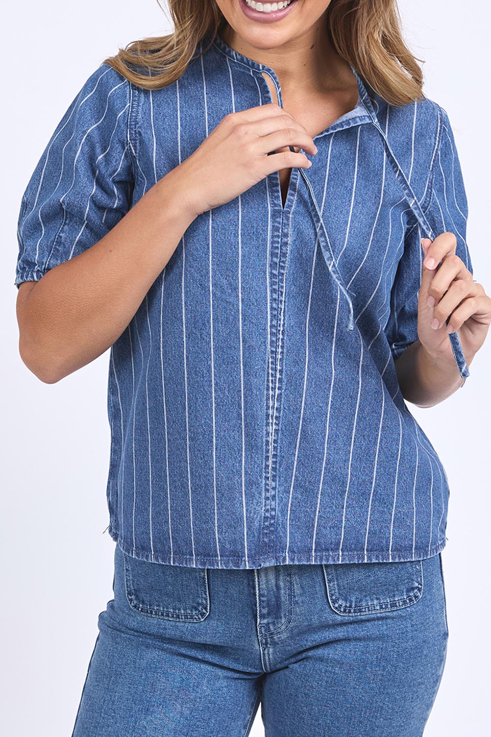 A model wearing the Tivoli Denim Top in colour Midblue (Blue), from the front, cropped image