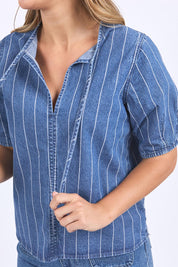 A model wearing the Tivoli Denim Top in colour Midblue (Blue), from the front, cropped image