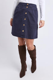 A model wearing the Elements Amanda Denim Skirt in colour Darksapph (Blue), from the front, cropped image