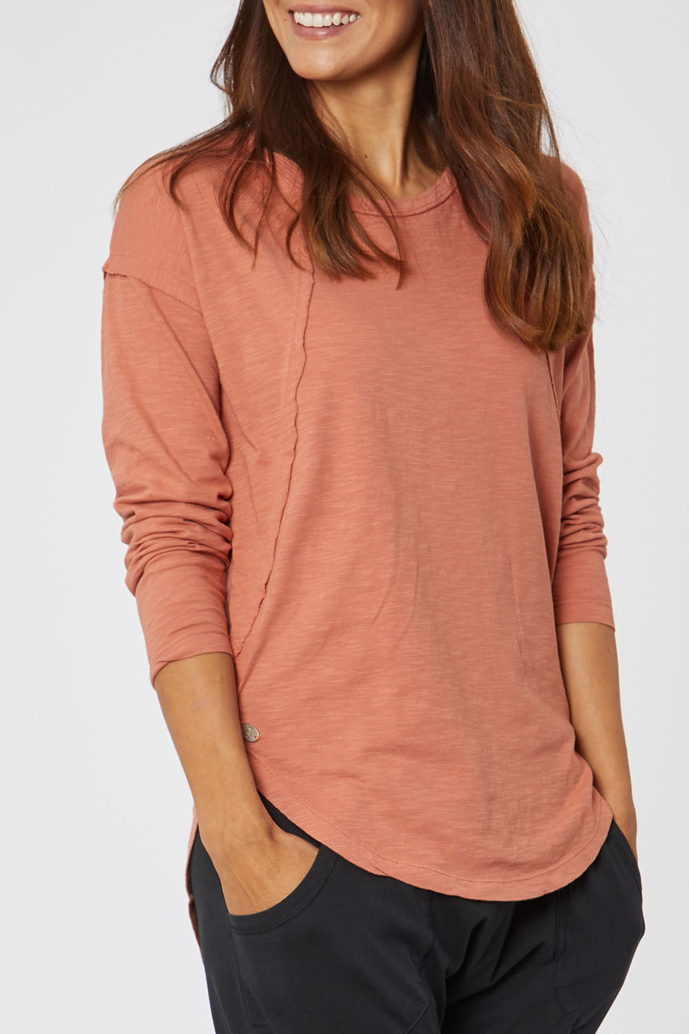Model Cara wearing size 10 of the Elements Mackenzie Long Sleeve Crew Tee in colour Copper, from the front, cropped image