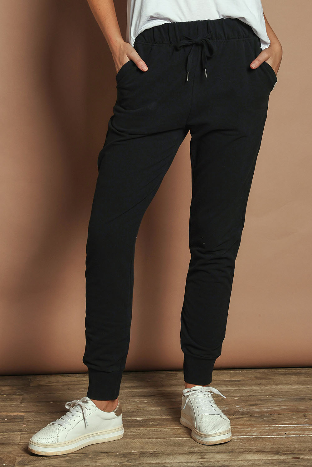 Model Madeline wearing size 10 of the Elements Lazy Days Pant in colour Black (Black), from the front, cropped image