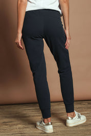 Model Madeline wearing size 10 of the Elements Lazy Days Pant in colour Navy (Blue), from the back