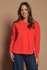 Model Madeline wearing size 10 of the Elements Simplified Cotton Crew in colour Brightred (Red), from the front, cropped image
