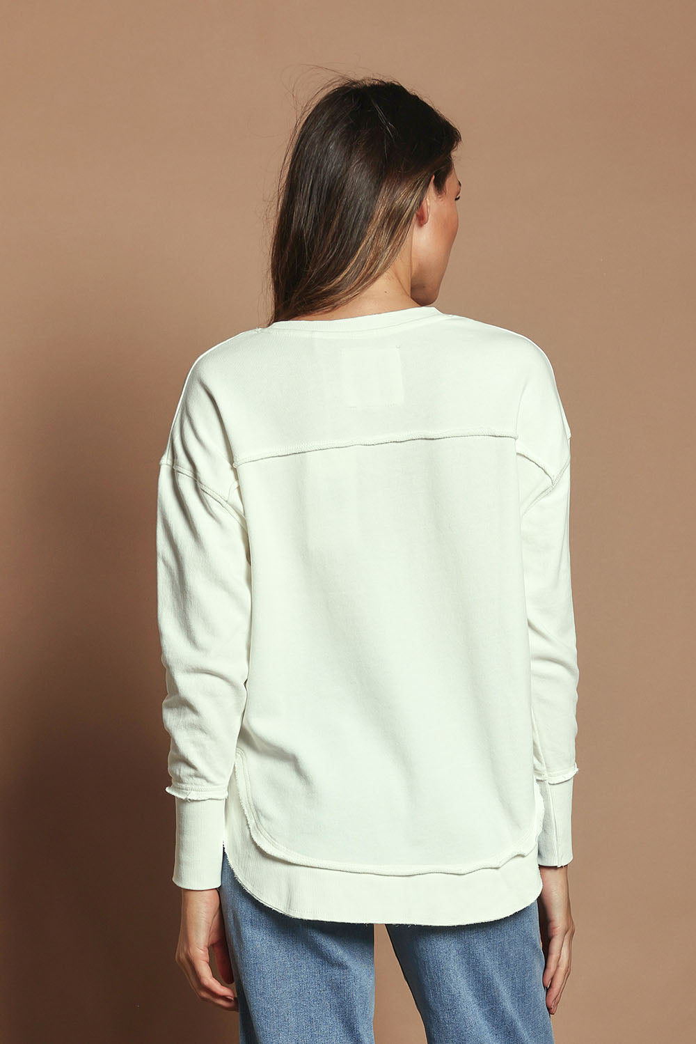 Model Madeline wearing size 10 of the Elements Simplified Cotton Crew in colour Ecru (White), from the back
