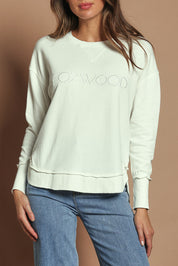 Model Madeline wearing size 10 of the Elements Simplified Cotton Crew in colour Ecru (White), from the front, cropped image