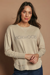 Model Madeline wearing size 10 of the Elements Simplified Cotton Crew in colour Oat, from the front, cropped image