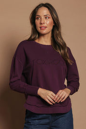 Model Madeline wearing size 10 of the Elements Simplified Cotton Crew in colour Plum (Purple), from the front, cropped image
