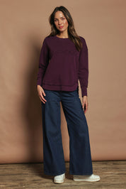 Model Madeline wearing size 10 of the Elements Simplified Cotton Crew in colour Plum (Purple), from the front, showing the whole outfit