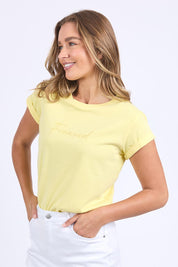 A model wearing the Elements Signature Cotton Tee in colour Lemon, from the front, showing the whole outfit