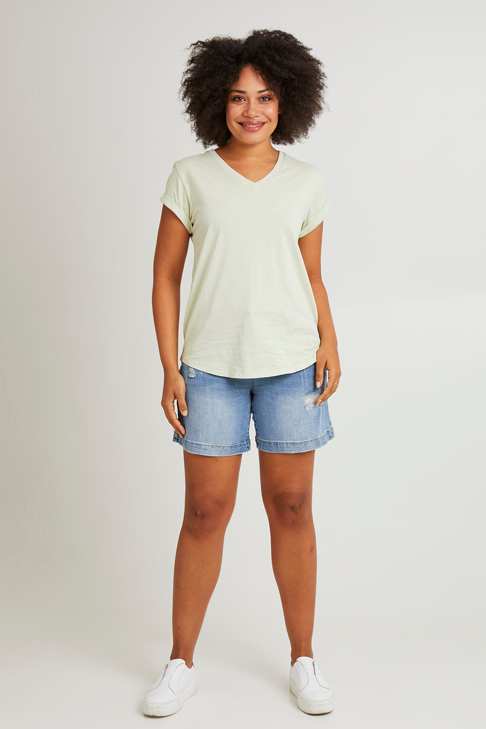 Model Olivia wearing size 10 of the Elements Manly Cotton Vee Tee in colour Foggreen (Green), from the front, showing the whole outfit
