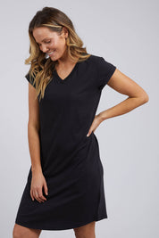 A model wearing the Elements Manly Vee Tee Dress in colour Black (Black), from the front, cropped image
