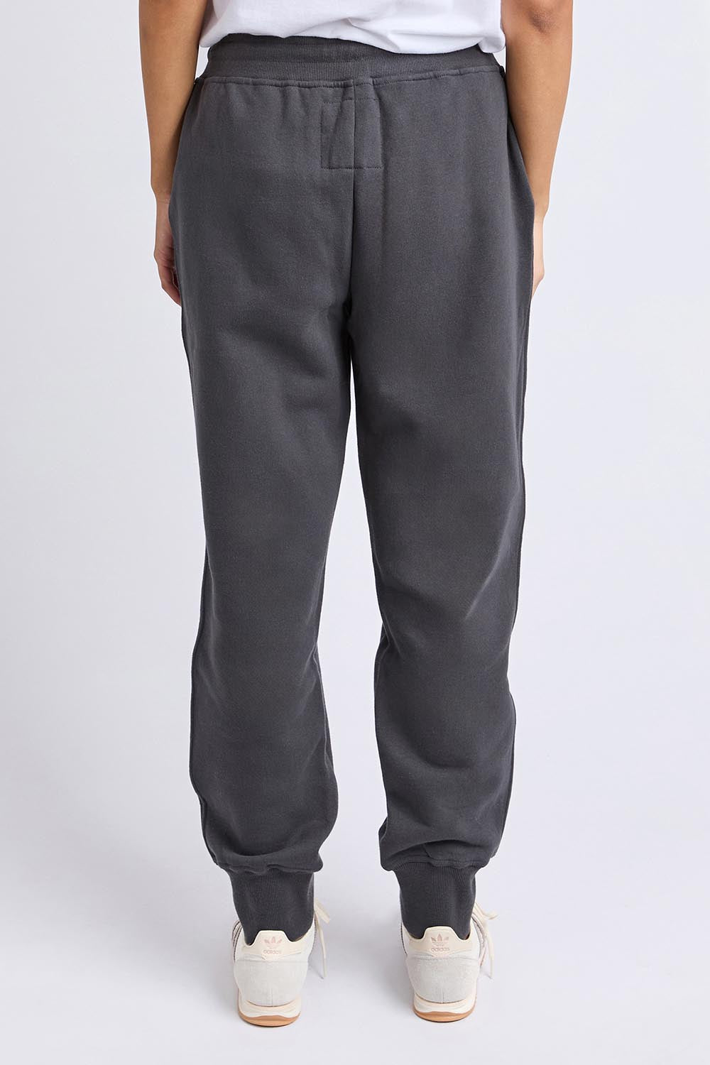 A model wearing the Elements Cotton College Track Pant in colour Coal (Grey), from the back