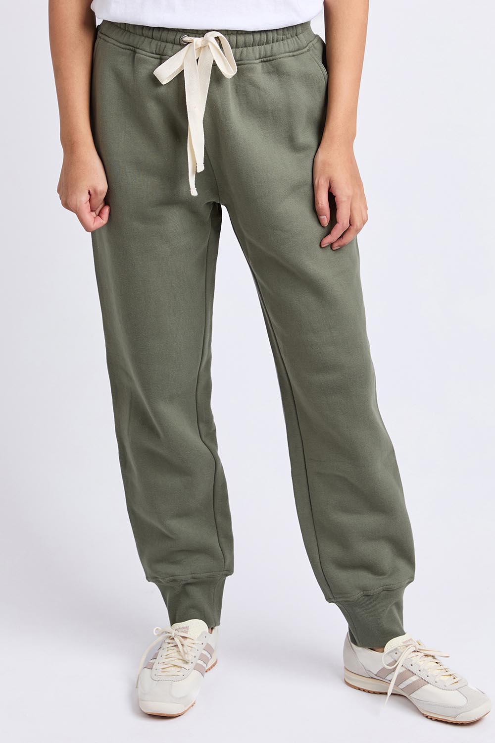 A model wearing the Elements Cotton College Track Pant in colour Khaki (Green), from the front, cropped image