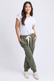 A model wearing the Elements Cotton College Track Pant in colour Khaki (Green), from the front, showing the whole outfit