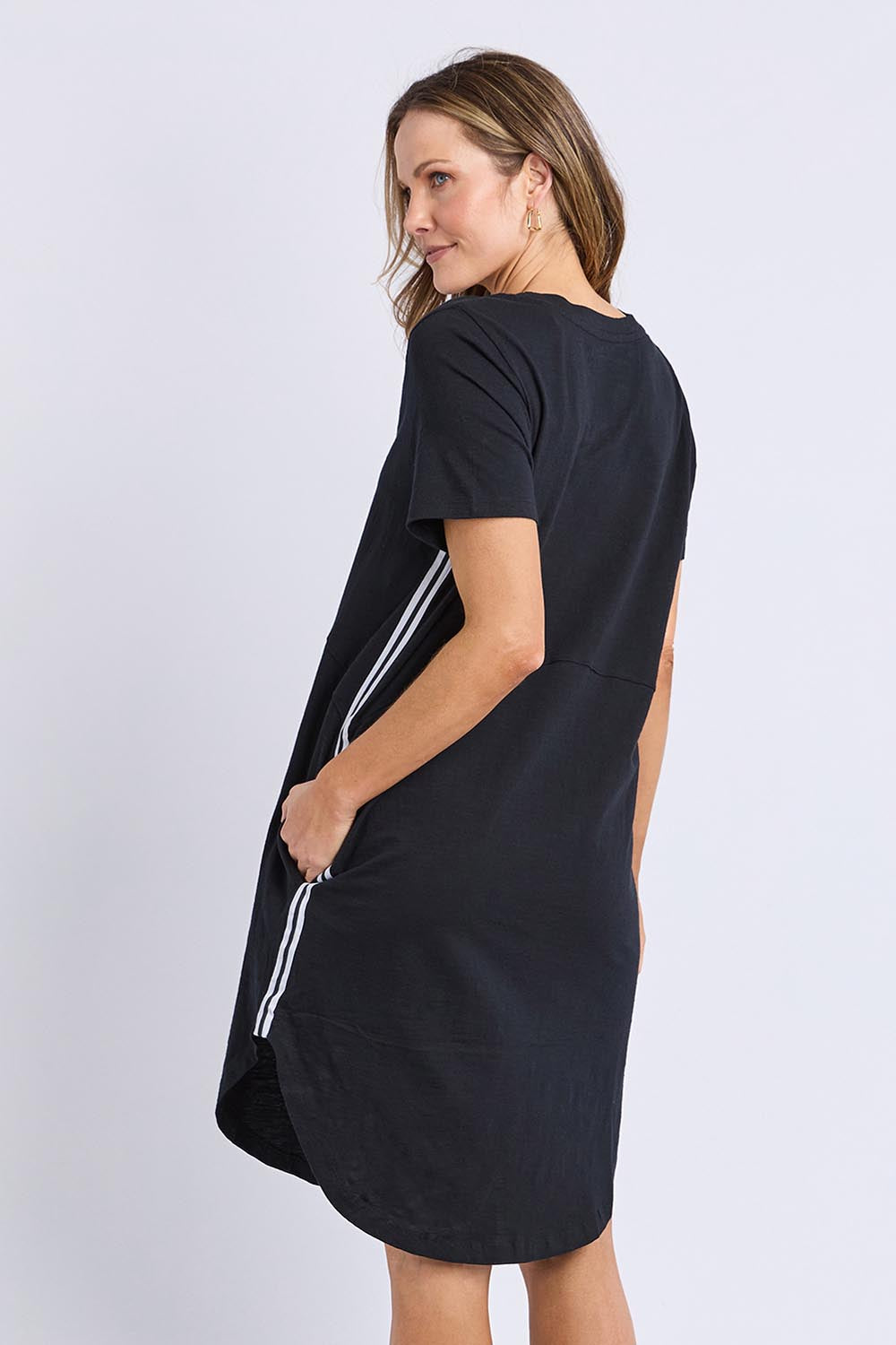 A model wearing the Elements Bay Tape Cotton Tee Dress in colour Black (Black), from the back