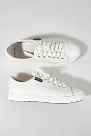 A model wearing size 7 of the Nat Leather Sneaker in colour White (White), from the front, showing the whole outfit