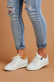 A model wearing size 8 of the Nat Leather Sneaker in colour White (White), from the front, showing the whole outfit