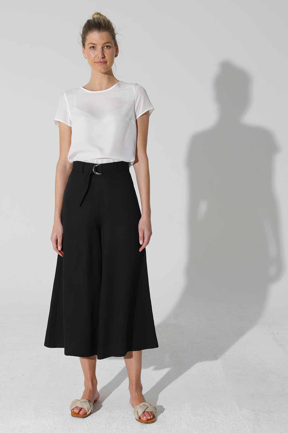 A model wearing the Before Sunset Pant in colour Black (Black), from the front, showing the whole outfit