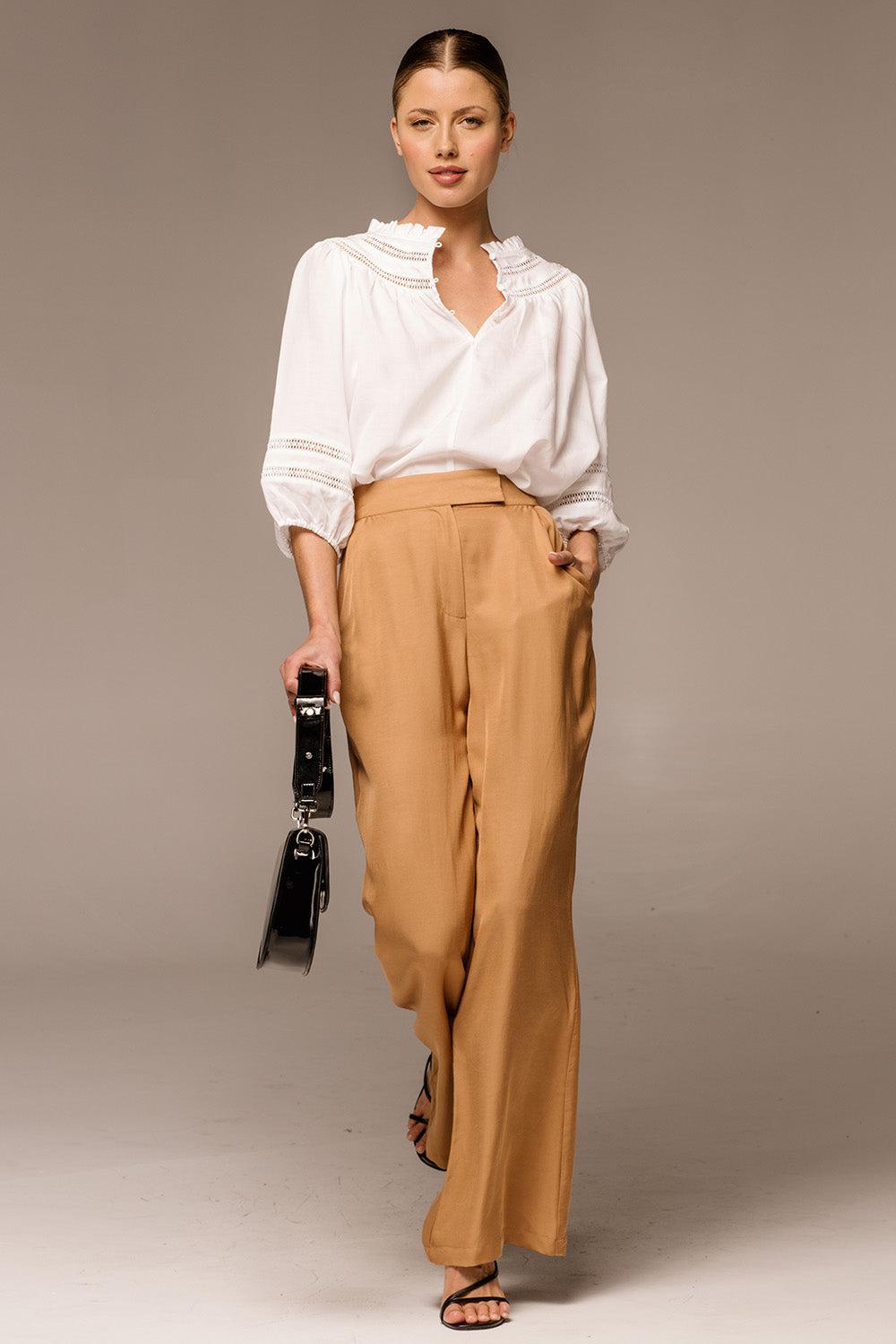 A model wearing the Heart & Soul Flare Pant in colour Caramel, from the front, showing the whole outfit