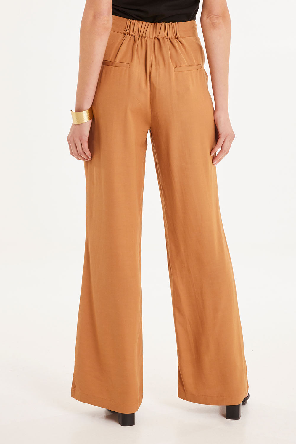 Model Madeline wearing size 10 of the Heart & Soul Flare Pant in colour Caramel, from the back