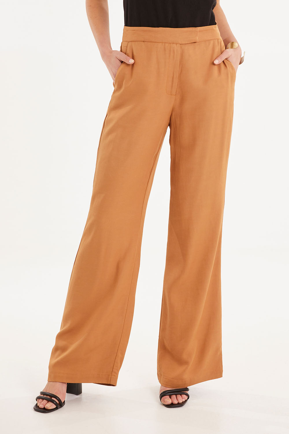 Model Madeline wearing size 10 of the Heart & Soul Flare Pant in colour Caramel, from the front, cropped image