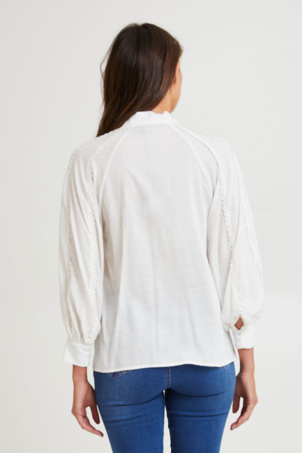 Model Madeline wearing size 10 of the Berry Kiss Linen Tencel Blend Blouse in colour Ivory (White), from the back