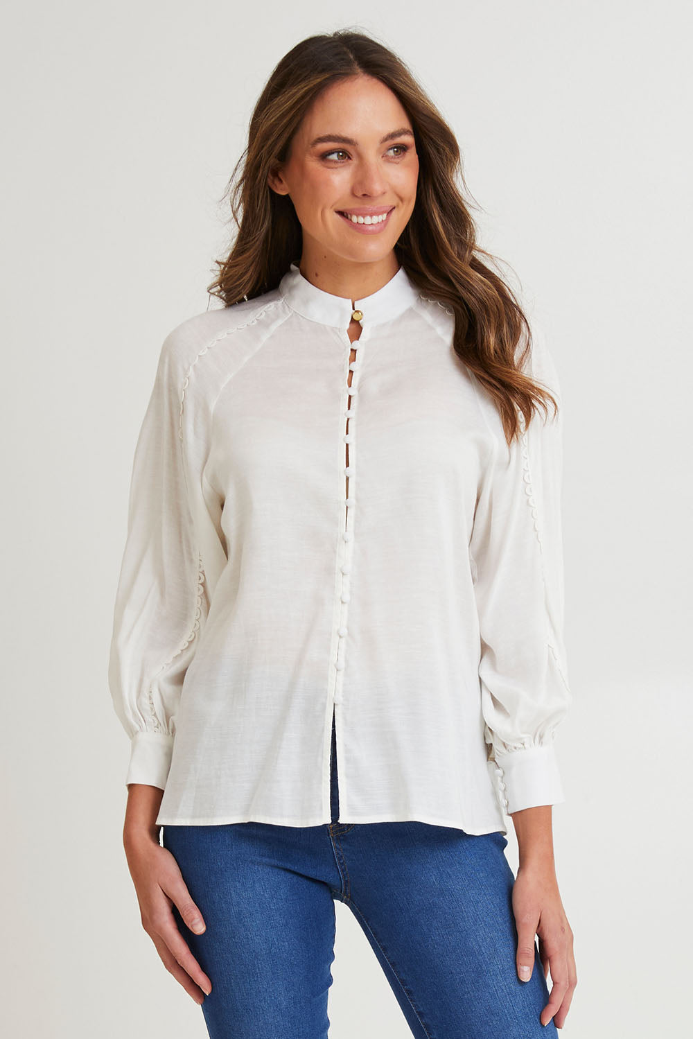 Model Madeline wearing size 10 of the Berry Kiss Linen Tencel Blend Blouse in colour Ivory (White), from the front, cropped image
