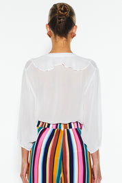A model wearing the Just Love Ruffle Blouse in colour White (White), from the back