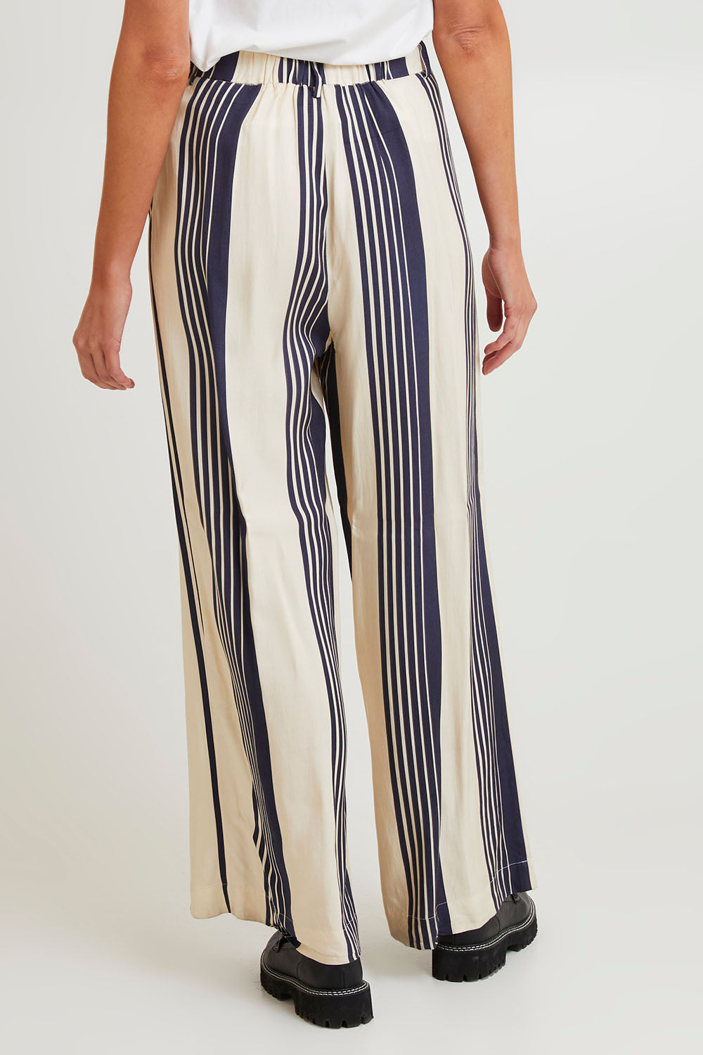 Model Madeline wearing size 10 of the Heartstopper Pant in colour Navystripe (Blue), from the back