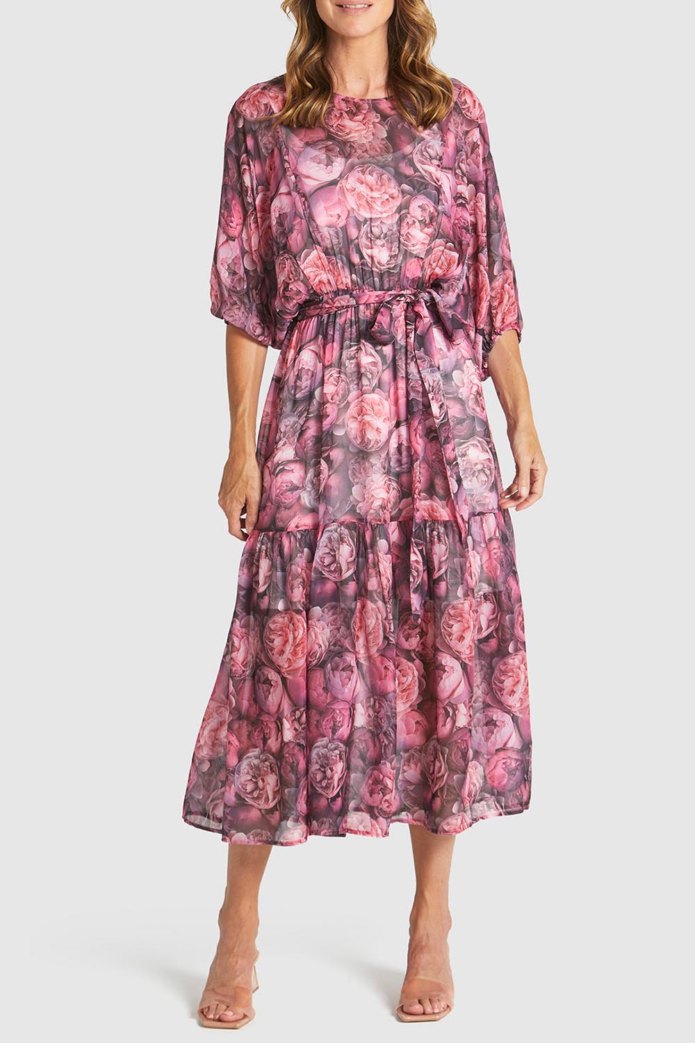 A model wearing the Phenomenon Dress in colour Peony (Pink), from the front, cropped image
