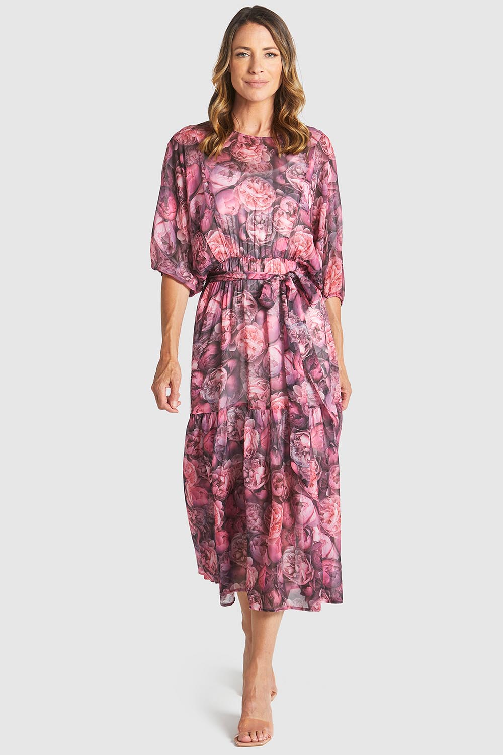 A model wearing the Phenomenon Dress in colour Peony (Pink), from the front, showing the whole outfit