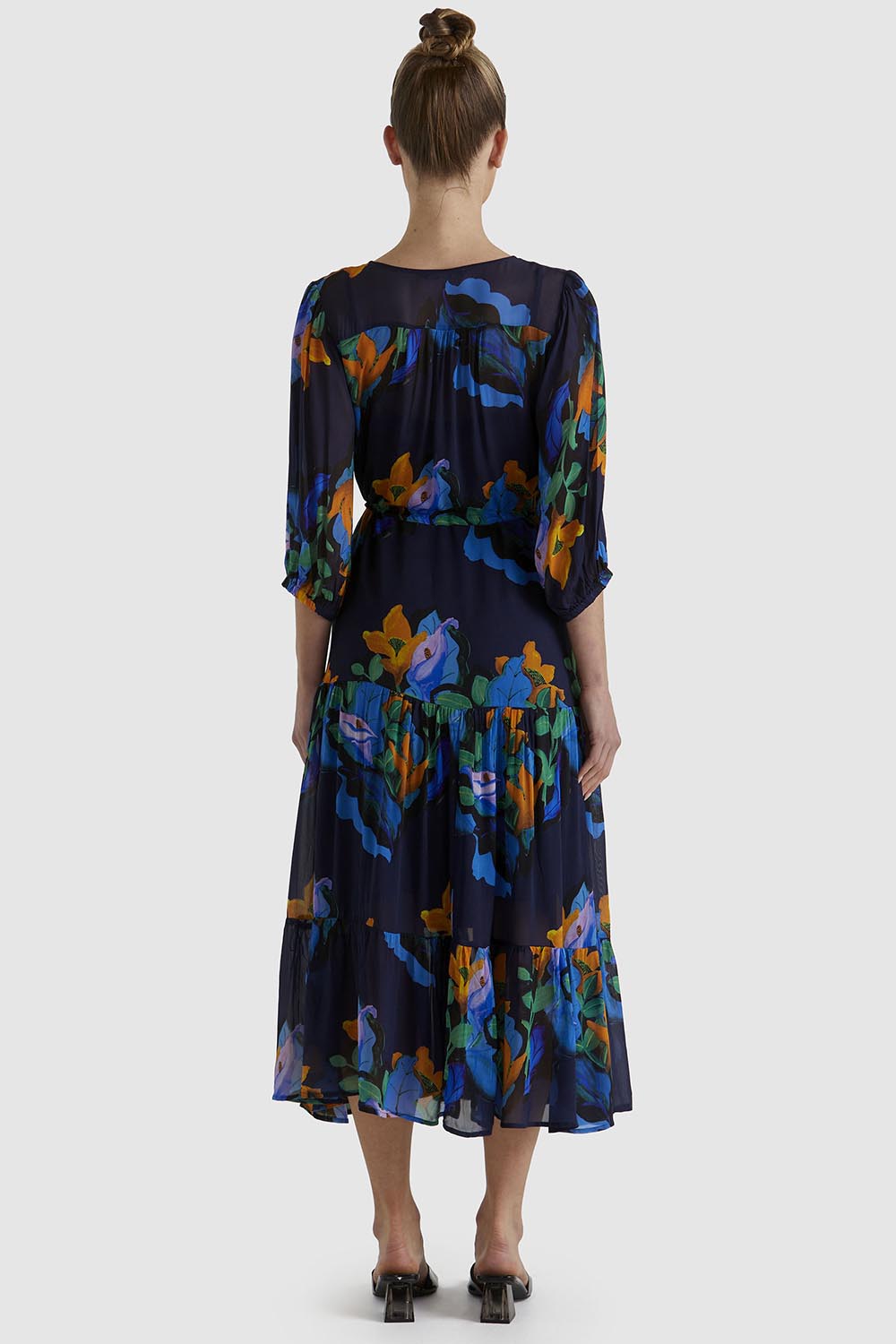 A model wearing the Twilight Dress in colour Navyfloral (Blue), from the back