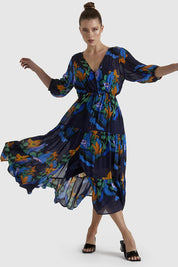 A model wearing the Twilight Dress in colour Navyfloral (Blue), from the front, showing the whole outfit
